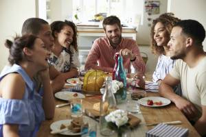 An image of a group of friends having a lively discussion around a dining table, suggesting a social setting where political views may be shared