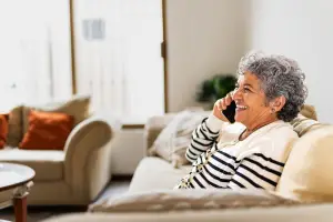 Older woman sitting on the couch talking on her phone