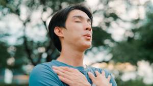 Man with eyes closed and two hands crossed over his chest