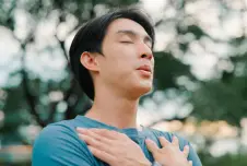 Man with eyes closed and two hands crossed over his chest