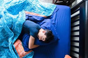 View from above of a boy sleeping in his bed