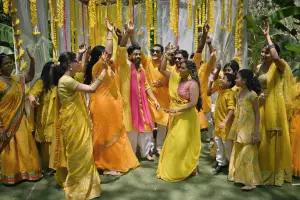 Family and friends dance with the bride and groom in a haldi ceremony