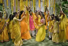 Family and friends dance with the bride and groom in a haldi ceremony