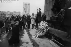 An image of Willy Brandt kneeling at the Warsaw Ghetto Memorial, surrounded by onlookers and photographers, capturing a historic moment of reconciliation.