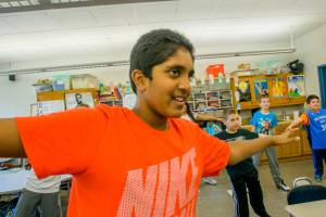 a picture of a boy in a class enjoying yoga with his classmates